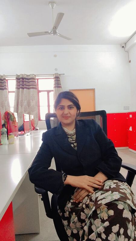 Gulafsha Naaz, seated at a desk in the office.